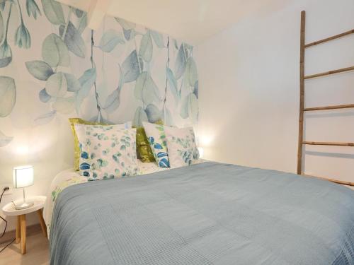 a bedroom with a bed with a blue bedspread at Holiday Home in Gargas with Pool and Nature in Gargas