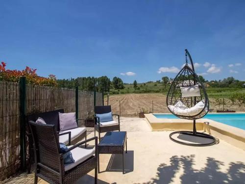a patio with chairs and a swing next to a pool at Holiday Home in Gargas with Pool and Nature in Gargas