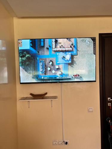 a flat screen tv hanging on a wall at appartement cité marine plage 5min in O Ben Slimane