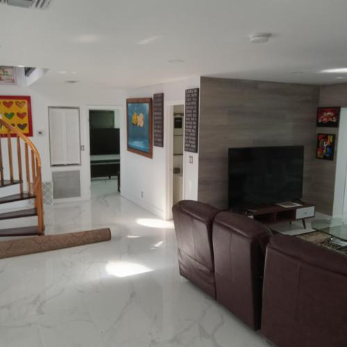 a living room with a couch and a flat screen tv at Premier Hostle in Fort Lauderdale