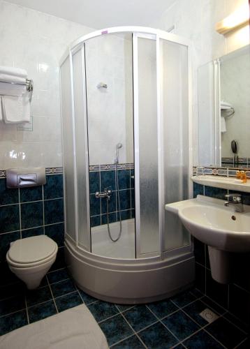 a bathroom with a shower and a toilet and a sink at Panorama Hotel - All Inclusive in Alanya