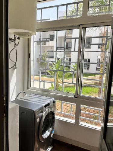 a washing machine in a room with a window at appartement cité marine plage 5min in O Ben Slimane