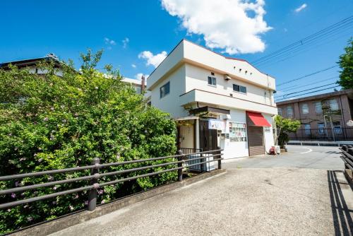 a white building with a fence in front of it at 大和の宿 Kitabukuro201 in Nara