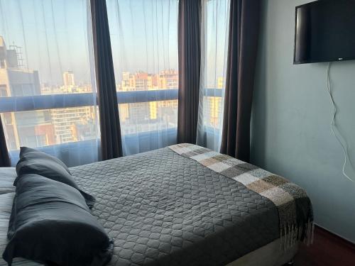 a bedroom with a bed and a large window at Never Give Up Suites in Santiago