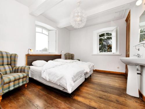 a white bedroom with a bed and a sink at Group Retreat in Robertville in Robertville