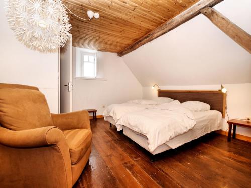 a bedroom with a bed and a couch and a chair at Group Retreat in Robertville in Robertville