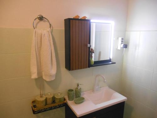 a bathroom with a sink and a mirror at Apartamento vista ao mar com ar in Salvador