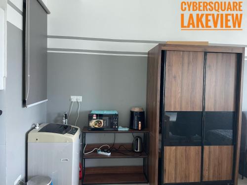 a kitchen with a refrigerator and a microwave at Cybersquare Lakeview with Netflix and Disney Hotstar in Cyberjaya