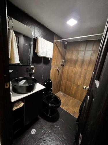 a bathroom with a toilet and a sink and a shower at Casa Fiore, Baños de Agua Santa in Baños