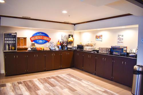 a restaurant kitchen with brown cabinets and a sign on the counter at Baymont by Wyndham Midland Center in Midland