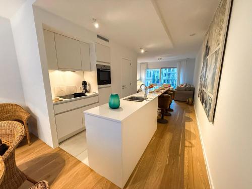 a kitchen with white cabinets and a green vase on a counter at Brussels City Apartment in Brussels