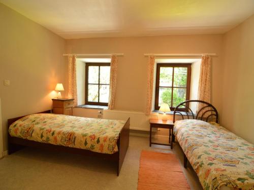a bedroom with two beds and two windows at Peaceful Retreat in Ferrières in Ferrières
