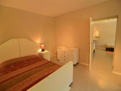 a bedroom with a bed and a dresser with a lamp at Peaceful Retreat in Ferrières in Ferrières