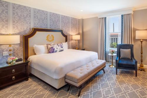 a hotel room with a bed and a chair at Willard InterContinental Washington by IHG in Washington