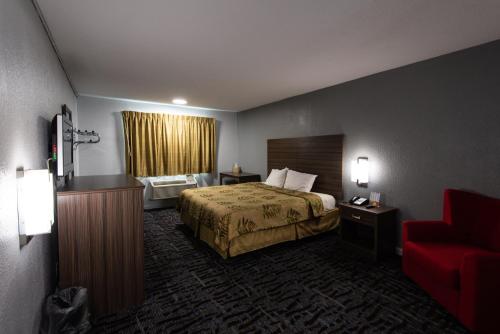 una camera d'albergo con un letto e un divano rosso di Regency Inn & Suites a Nashville