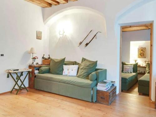 a living room with a green couch and a table at Modern Apartment, Bressanone in Bressanone