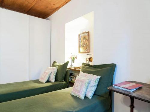 a room with two green beds and a table at Modern Apartment, Bressanone in Bressanone