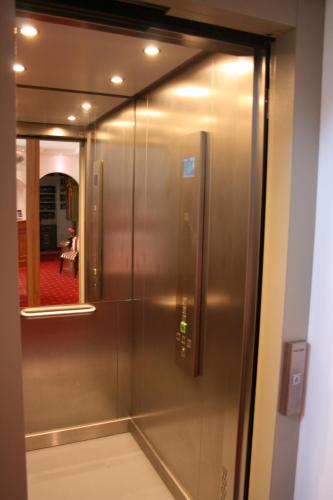 a sliding glass door of a elevator in a room at Hotel garni Almenrausch und Edelweiss in Garmisch-Partenkirchen