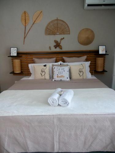 a bed with two towels on top of it at SWEET HOME plage privée in Folle Anse