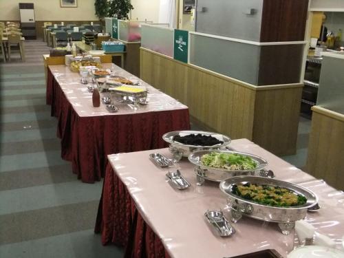 una fila di tavoli con ciotole di cibo sopra di 蔵王ライザウッディロッジ a Kaminoyama