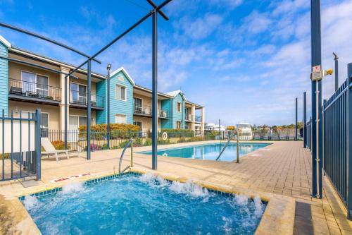 a swimming pool with a house and a building at Waterfront bliss, spacious corner block in Mandurah