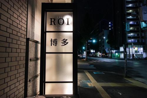 a sign on the side of a building at night at Hotel ROI 博多 in Fukuoka