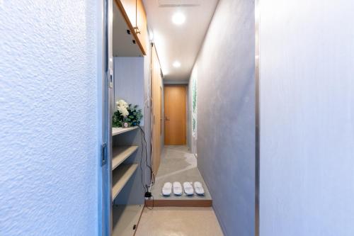 a hallway with a door leading into a room with white walls at Sakura Fan 2F in Tokyo