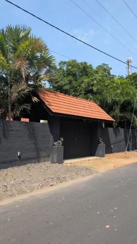 a building with an orange roof next to a street at 501 Thumpalai Road in Point Pedro