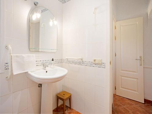 ein weißes Badezimmer mit Waschbecken und Spiegel in der Unterkunft Holiday Home in La Cala de Mijas by the Beach in La Cala de Mijas