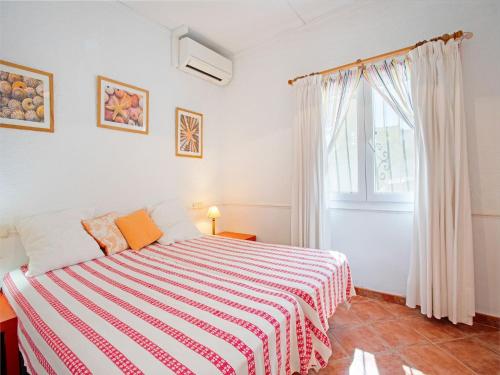 ein Schlafzimmer mit einem Bett mit einer gestreiften Decke in der Unterkunft Holiday Home in La Cala de Mijas by the Beach in La Cala de Mijas