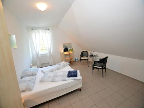 a bedroom with a bed and chairs in a attic at Villa in Nemojov near Giant Mountains in Nemojov