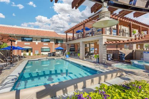 a pool with chairs and umbrellas at a hotel at Best Western Plus Canyonlands Inn in Moab