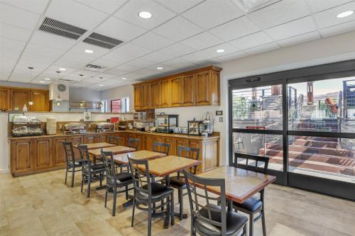 a kitchen with wooden tables and chairs and a large window at Best Western Plus Canyonlands Inn in Moab