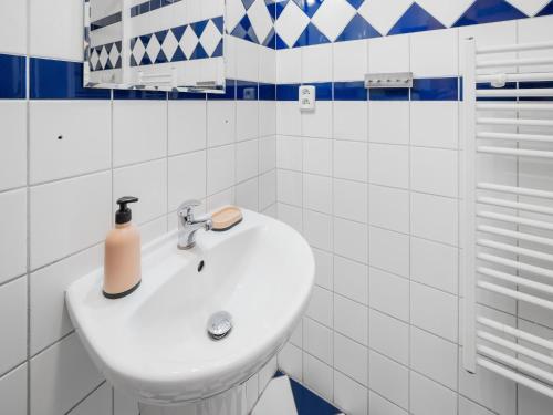 un lavandino bianco in un bagno con piastrelle bianche e blu di Lakeside Lipno Holiday Stay a Lipno nad Vltavou