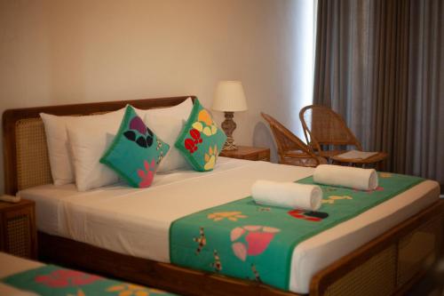 a bedroom with a bed with colorful pillows at Coop Safari Hotel in Tissamaharama