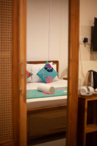 a bedroom with a bed with pillows on it at Coop Safari Hotel in Tissamaharama