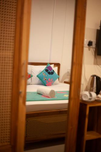 a small bed with pillows on it in a room at Coop Safari Hotel in Tissamaharama