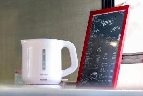 a coffee cup next to a menu on a table at Grampus Inn Shirahama in Shirahama