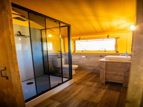 a bathroom with a shower and a toilet and a sink at Safari Tent in Markelo near Nature Park in Markelo