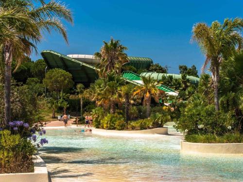 a resort with palm trees and a water park at Apartment for 2 people in Roses with river view in Roses