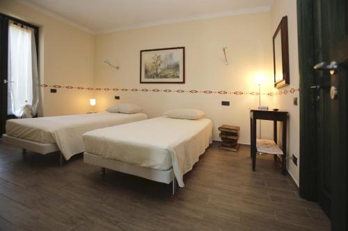a hotel room with two beds and a table at Ospitidelpero in Piozzo