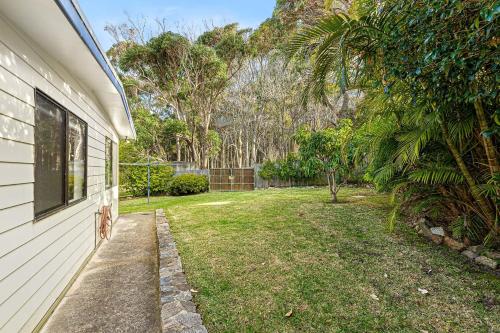 a yard next to a house with a window at The Palms Mystery Bay in Mystery Bay