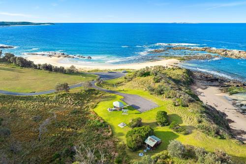an aerial view of a beach with a tent and the ocean at The Palms Mystery Bay in Mystery Bay
