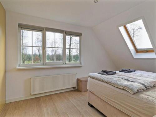 a bedroom with two beds and two windows at Villa in Bosrijk near Horsterwold Forest in Zeewolde