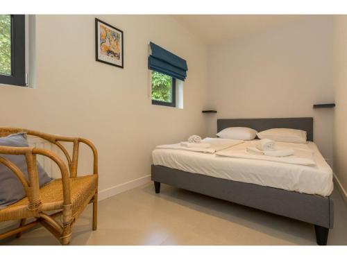 a bedroom with a bed and a chair in it at Holiday Home in Dishoek near Beach & Dunes in Dishoek