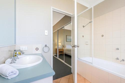 a bathroom with a sink and a tub and a shower at Waterfront bliss, spacious corner block in Mandurah