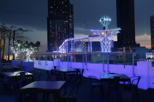 a restaurant with tables and chairs at night at Wyndham Garden i-City Shah Alam in Shah Alam