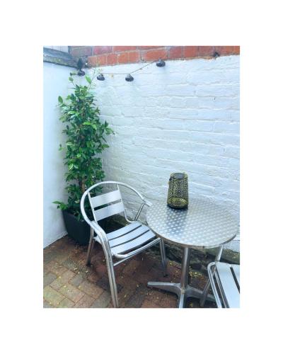 a table and two chairs and a table and a plant at Hay On Wye Welsh Townhouse in Hay centre in Hay-on-Wye