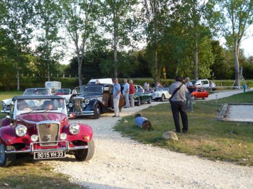 a red car parked next to a group of cars at Chalet sur pilotis avec terrasse pour 4 personnes - API-1-52-496 in Moncrabeau