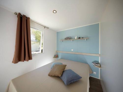 a small bedroom with a bed with a window at Mobil home 5 pers à Avrillé avec terrasse - API-1-52-587 in Avrillé